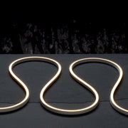 Warm white side-bend LED neon strip in a curved loop, glowing