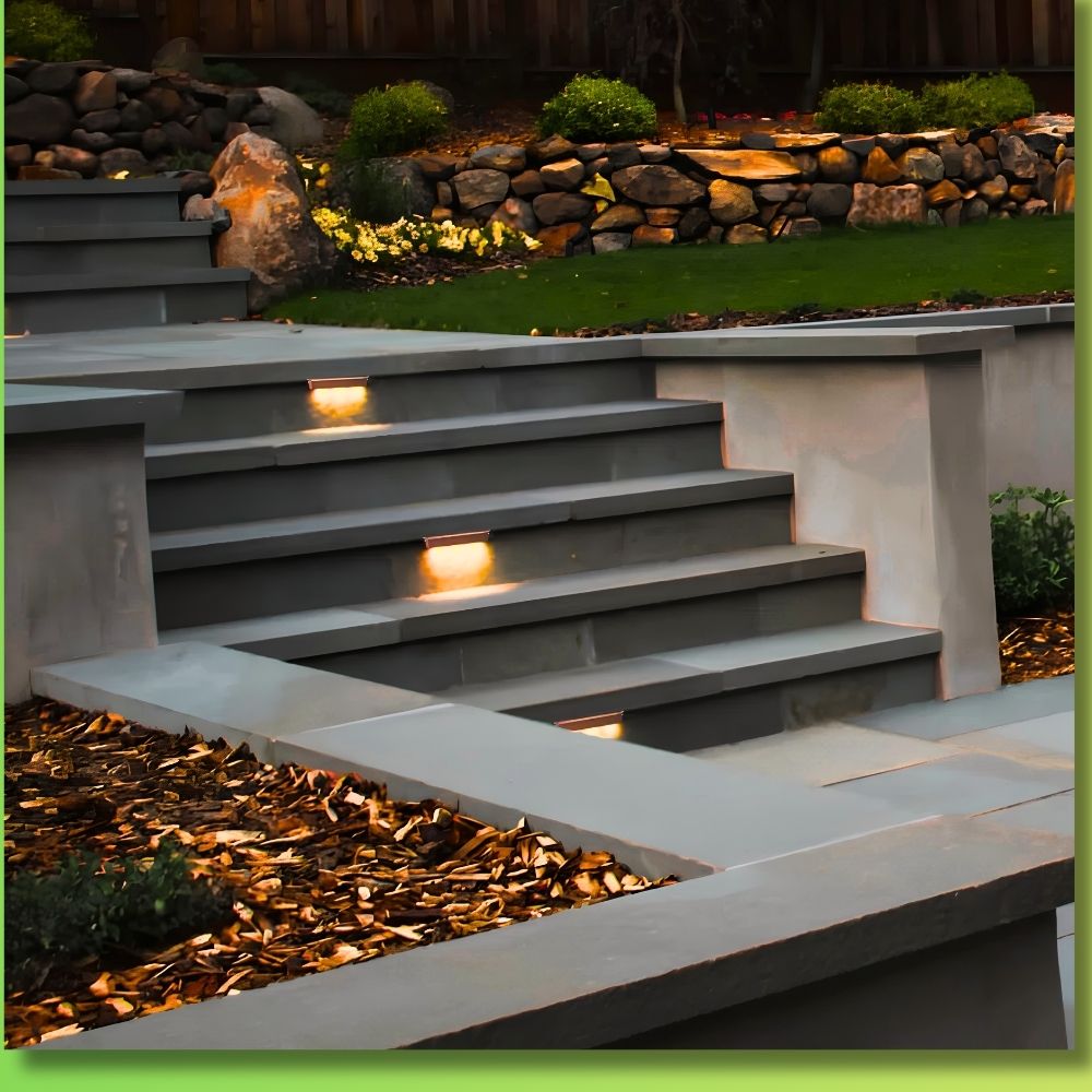 Installed gray aluminum hardscape step light fixture emitting warm light