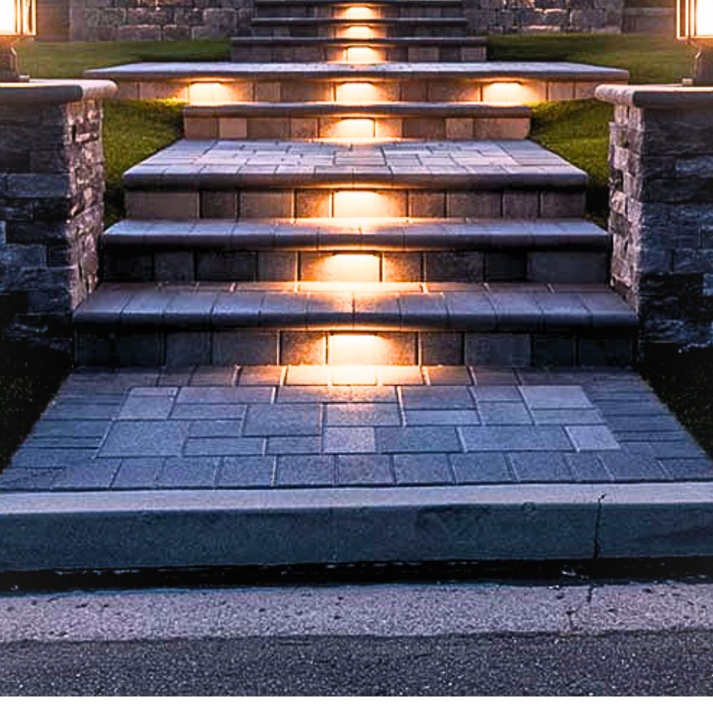Warm 2700K hardscape LED light strip fixtures in sand aluminum, glowing along steps