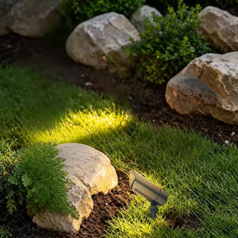 Black ground-mounted landscape LED accent light with angled cylindrical head