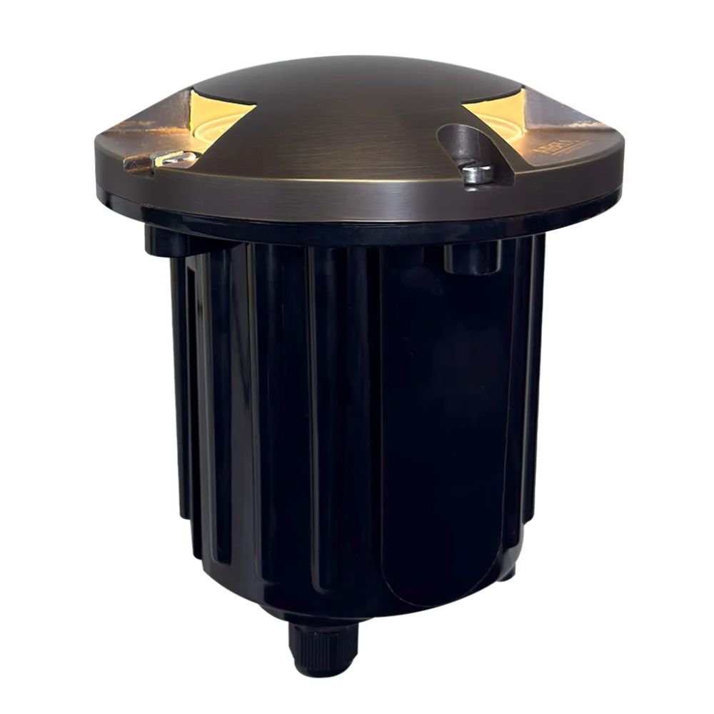LED well light with brass top accents and black ribbed housing, front corner view