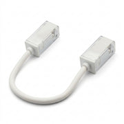 Flexible tape-to-tape LED connector with white cable and gray housing, clear end caps