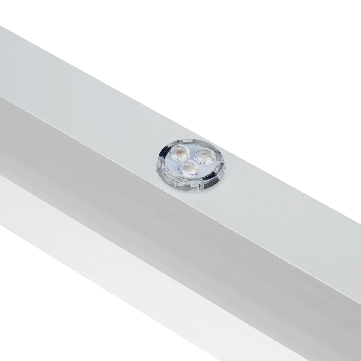 Close-up of recessed clear dot lens set into the white 45-degree channel trim