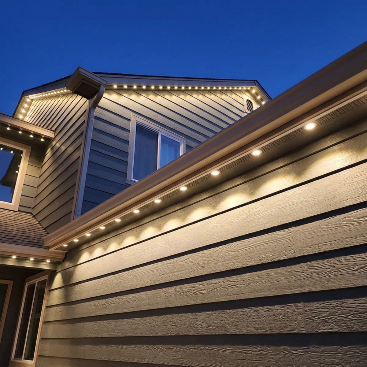 Outdoor twilight trim lighting channel with warm LED strip along a building edge