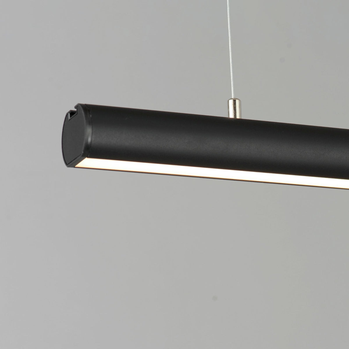 Black linear LED pendant light close-up of end cap and warm light strip