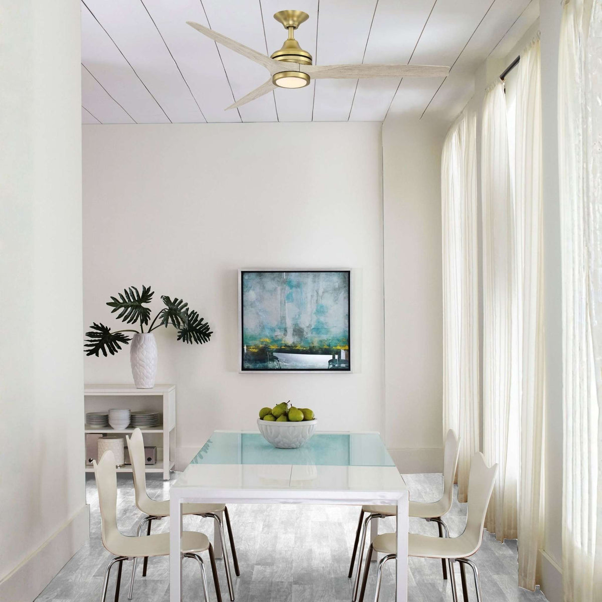 Brushed brass ceiling fan with blades installed in a modern dining space