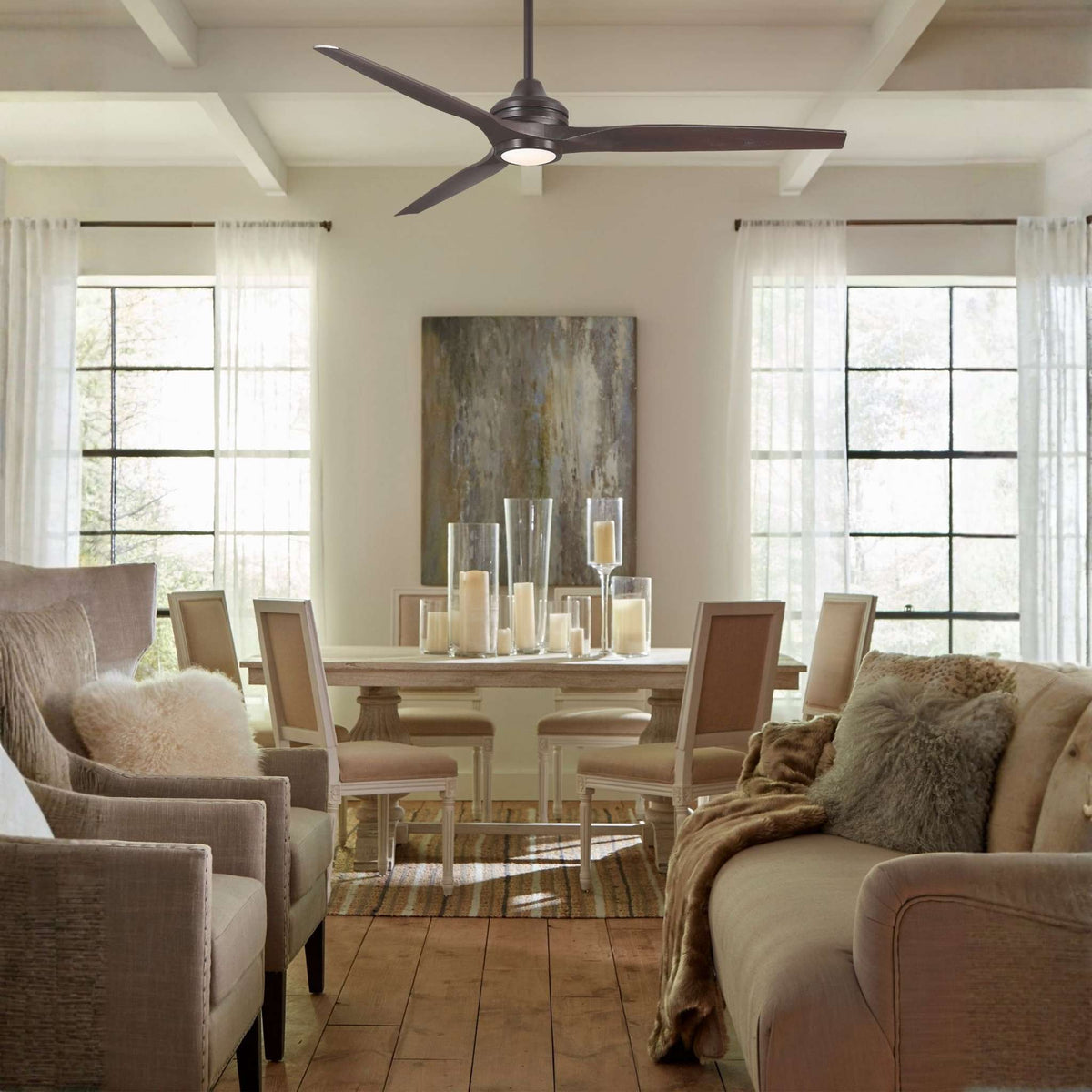 Dark bronze ceiling fan motor with sweeping blades installed on a living room ceiling