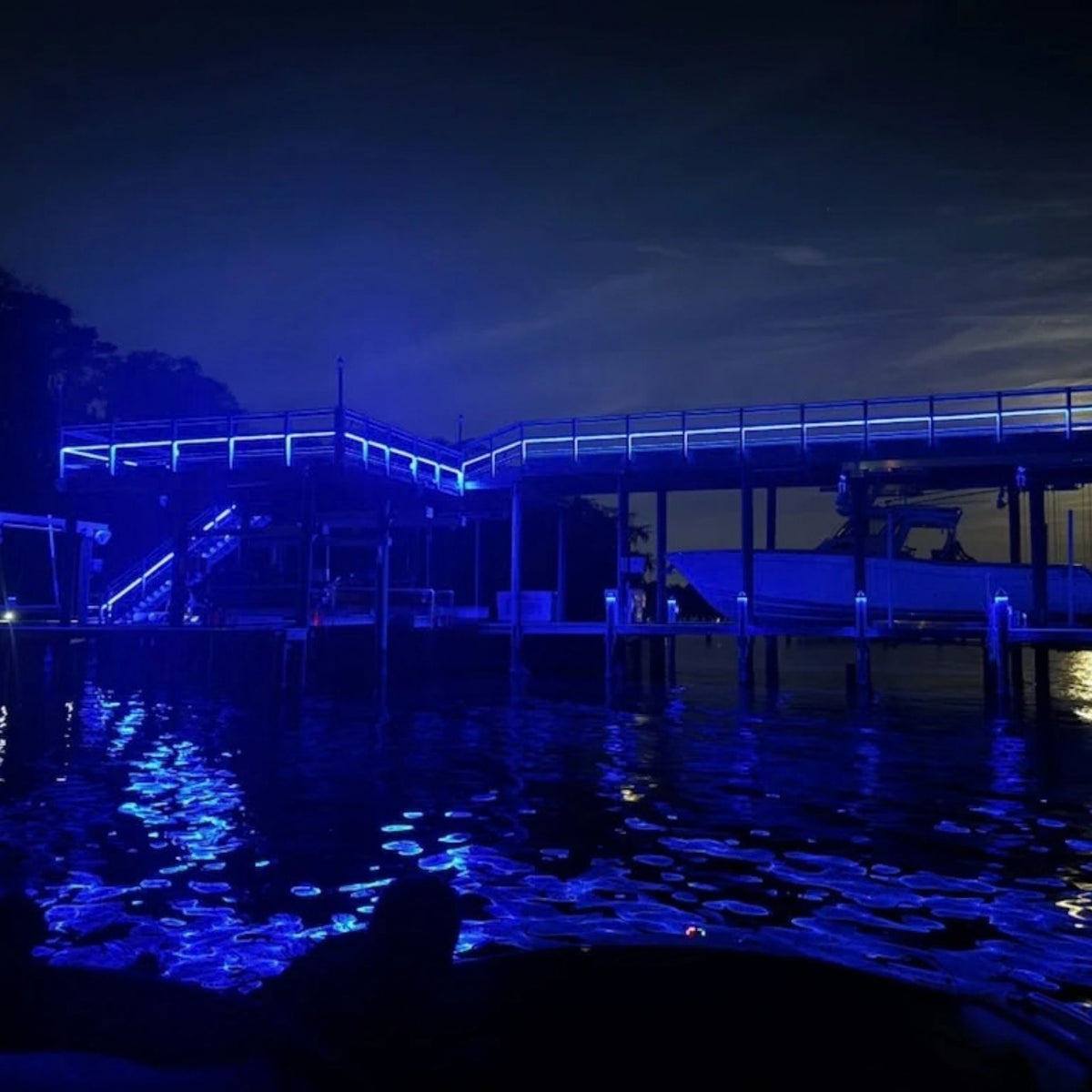 Blue outdoor neon tape light outlining structures with a continuous glowing line