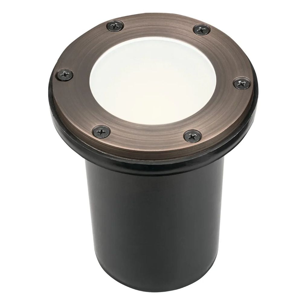 In-ground landscape light fixture with round brass bezel and black housing