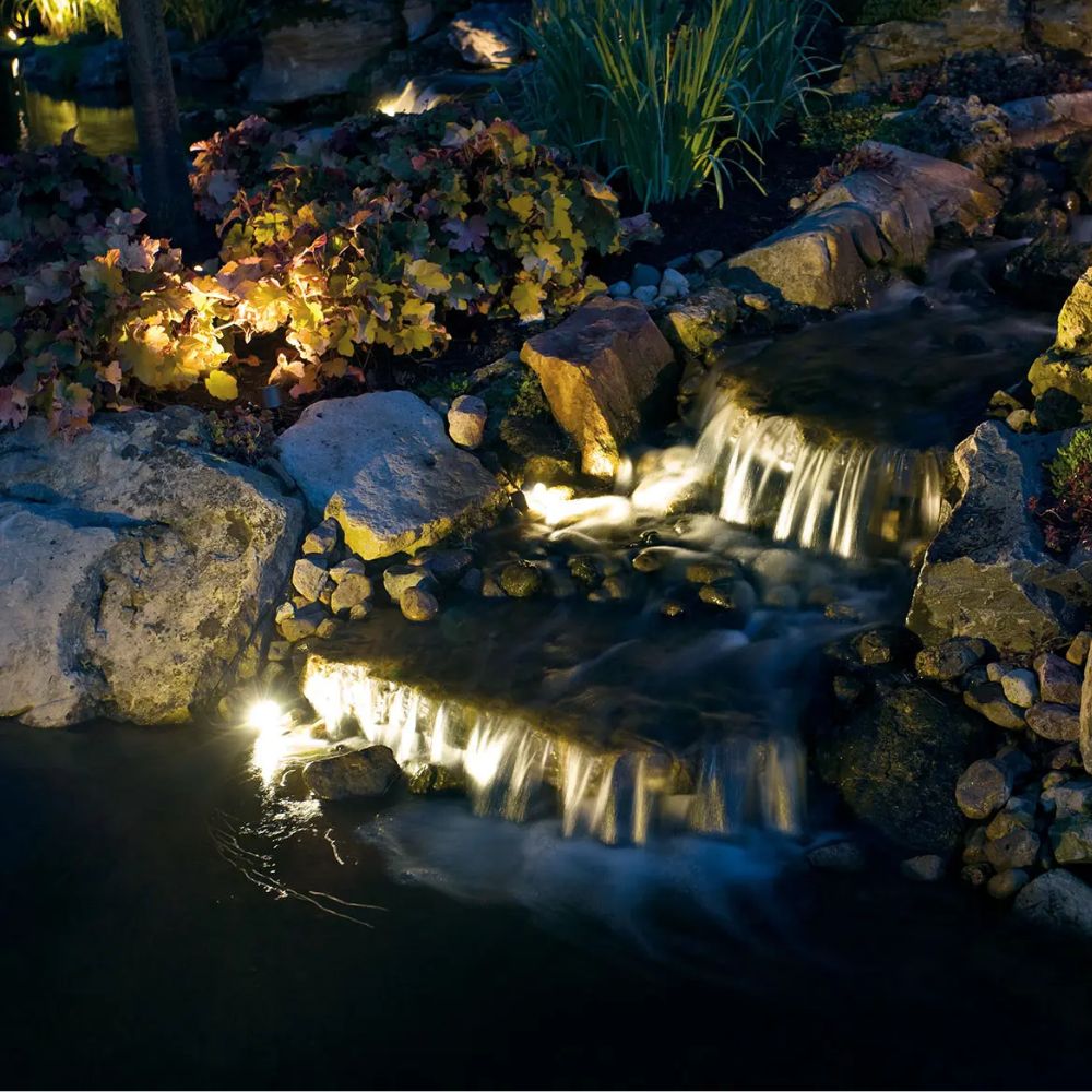 Underwater LED accent lights glowing beside rocks with light beams in water