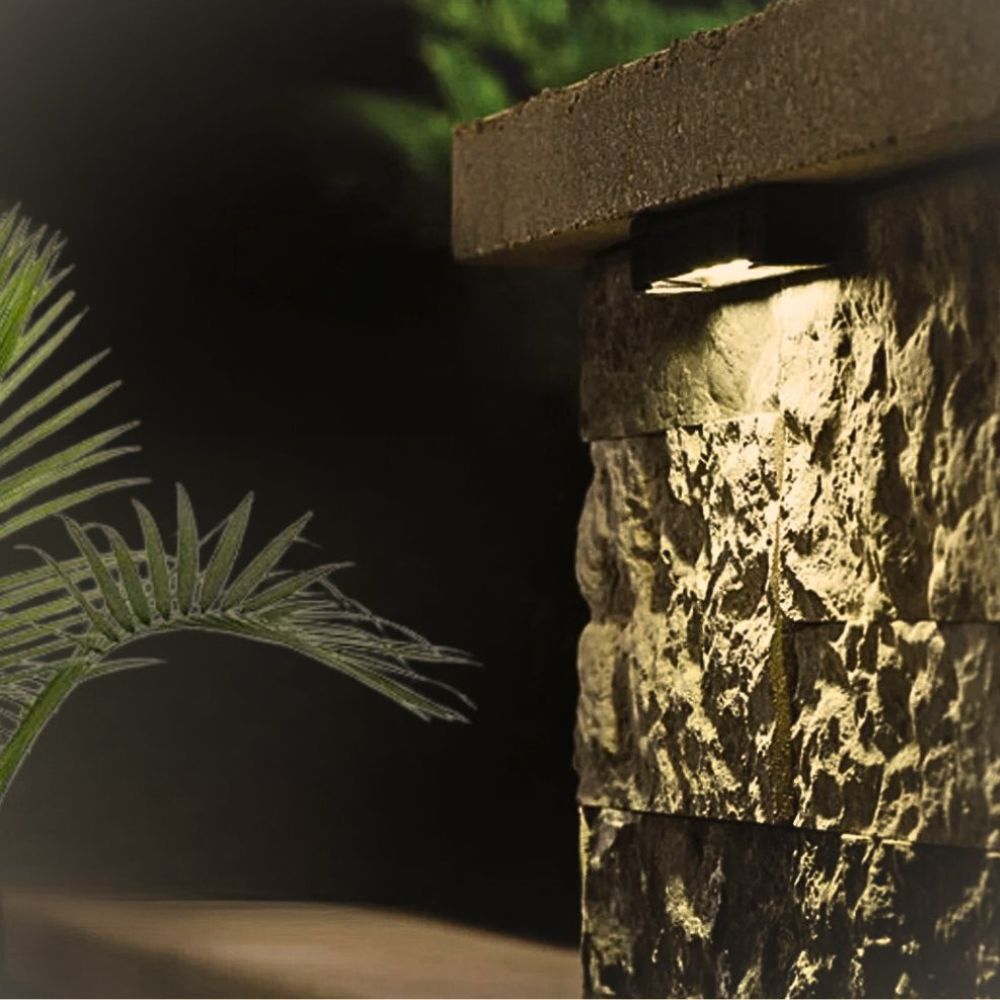 12V hardscape LED light casting warm beam along stone wall
