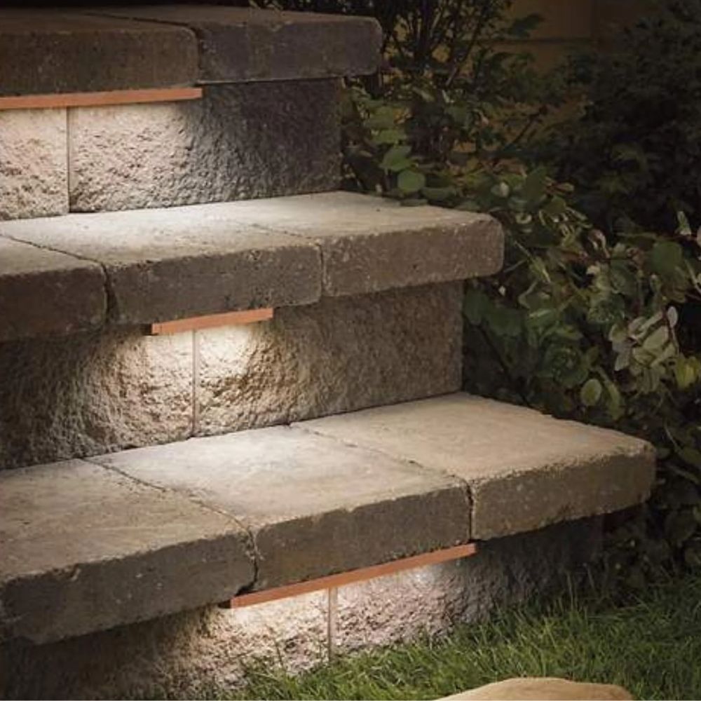 Warm LED step lighting illuminating stone hardscape steps and walkway