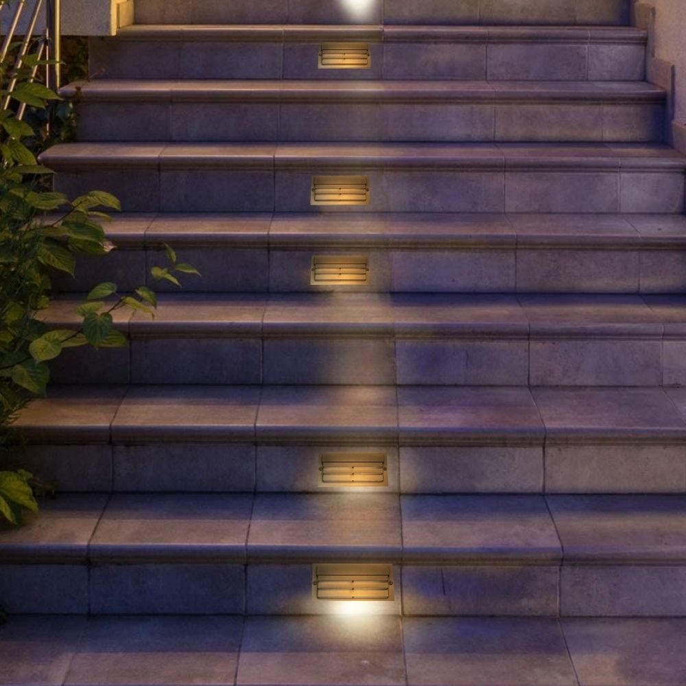 Bronze louvered LED step lights illuminating stone stairs in a row