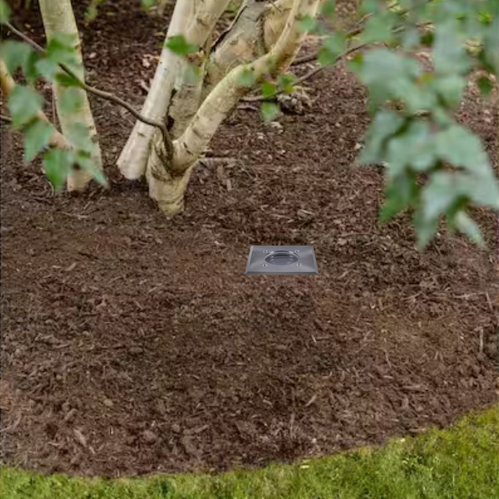 Square in-ground LED well light with flat stainless face installed in soil
