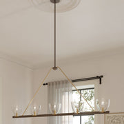 5-light linear chandelier with clear glass shades and dark bronze bar in a dining room