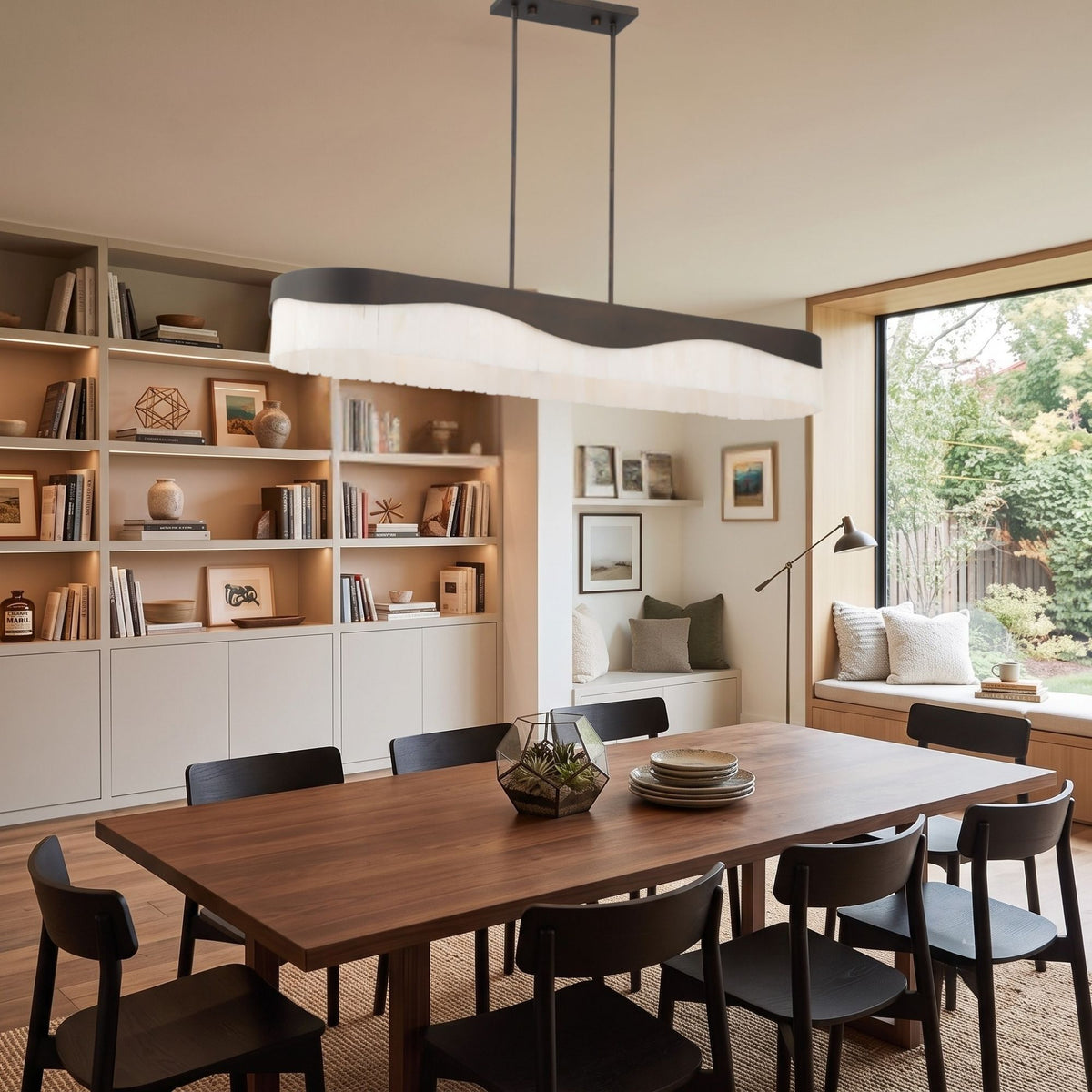 Dark bronze island pendant with white pleated drum shades over a dining table