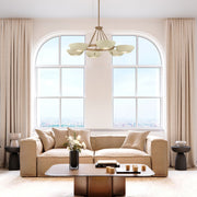 Patina brass chandelier with six soft sand bowl shades suspended above seating