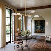 6-light chandelier above living room seating with gold arms and gray woven cone shades