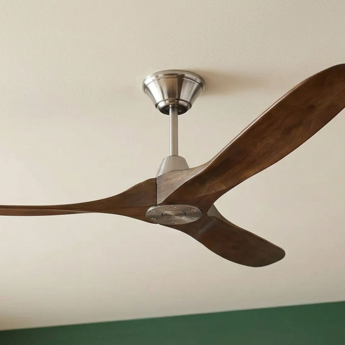 Ceiling fan with dark walnut blades and brushed steel finish, side angle