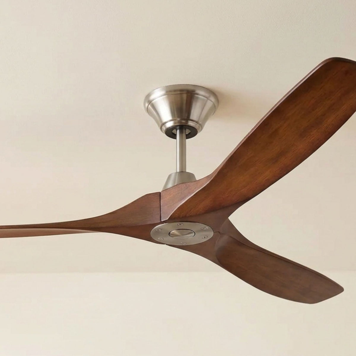 Ceiling fan with brushed steel housing and koa wood blades, mounted on ceiling
